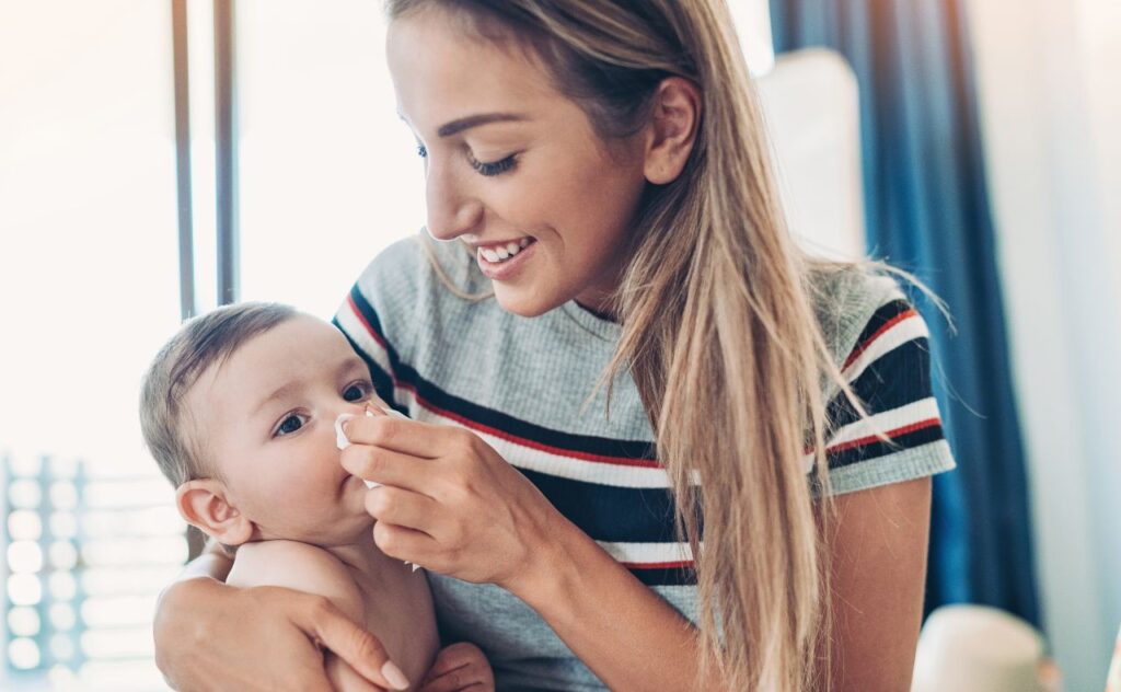 Mother wiping baby's nose