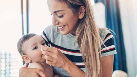 Mother wiping baby's nose