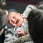 Newborn baby colic close up. Young parents and crying baby 1 month old.