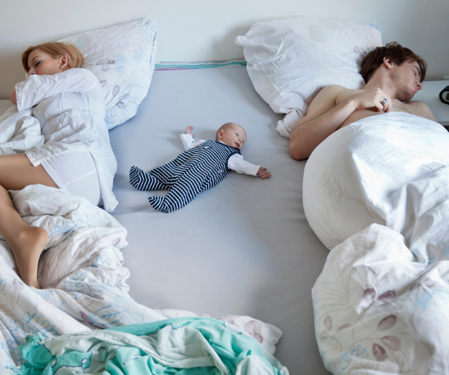 parents in bed with newborn