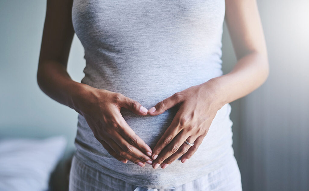 Cropped shot of a pregnant woman touching her belly
