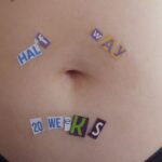 Close-up of a woman belly pregnant with wrote on top "Half Way - 20 weeks"