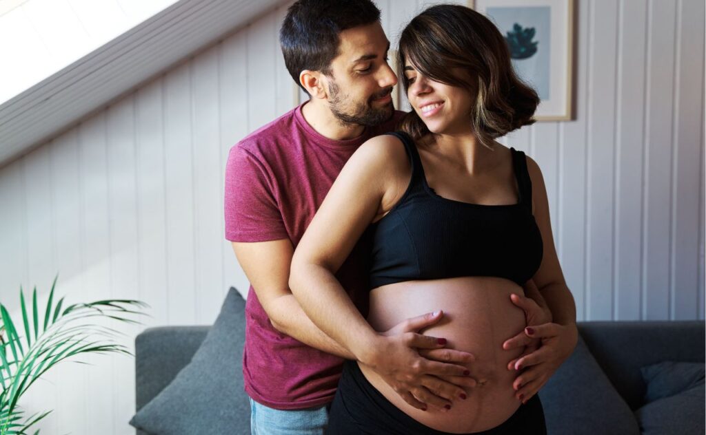Pregnant couple showing off baby bump