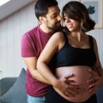 Pregnant couple showing off baby bump