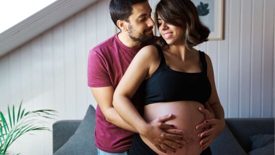 Pregnant couple showing off baby bump