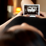 Woman on bed holding ultrasound image