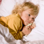 Small child snuggled into bed