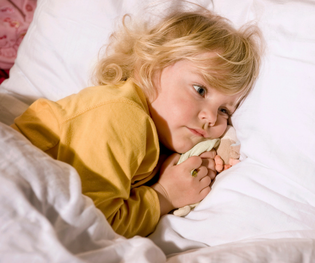 Small child snuggled into bed