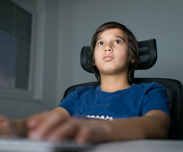 Young boy plays video game online