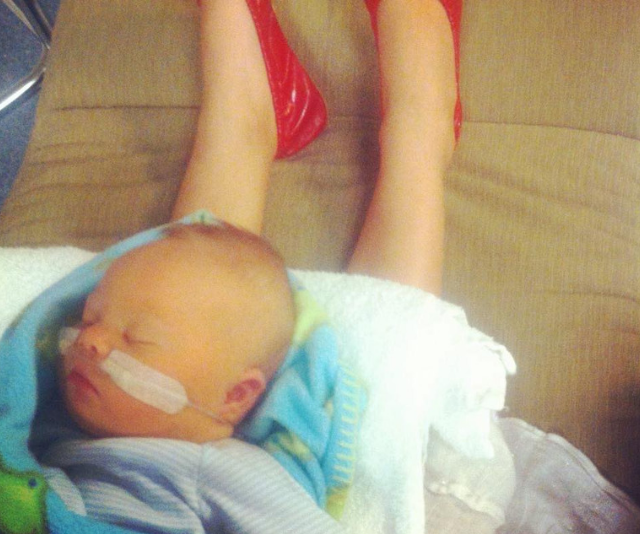 Newborn baby with Down Syndrome sleeping on mother's lap