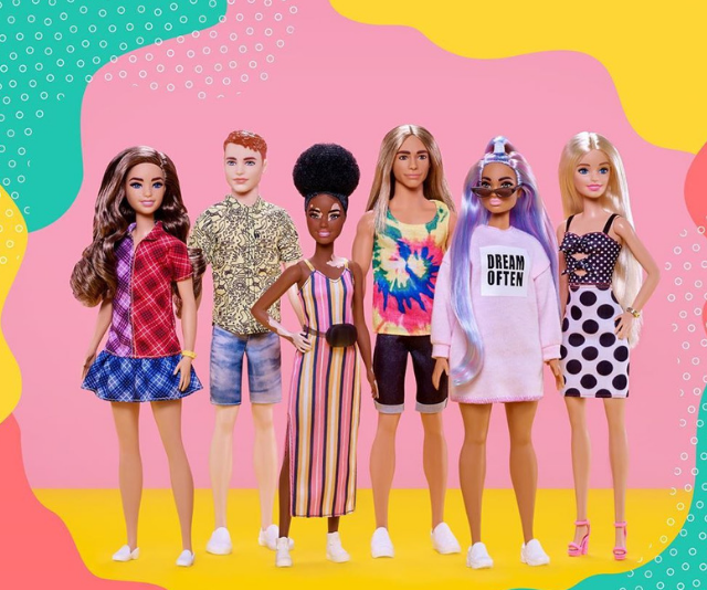 6 diverse Barbie dolls lined up against pink background