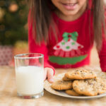 Hispanic girl setting out milk and cookies for Santa