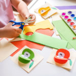 Image showing child's hands cutting craft paper