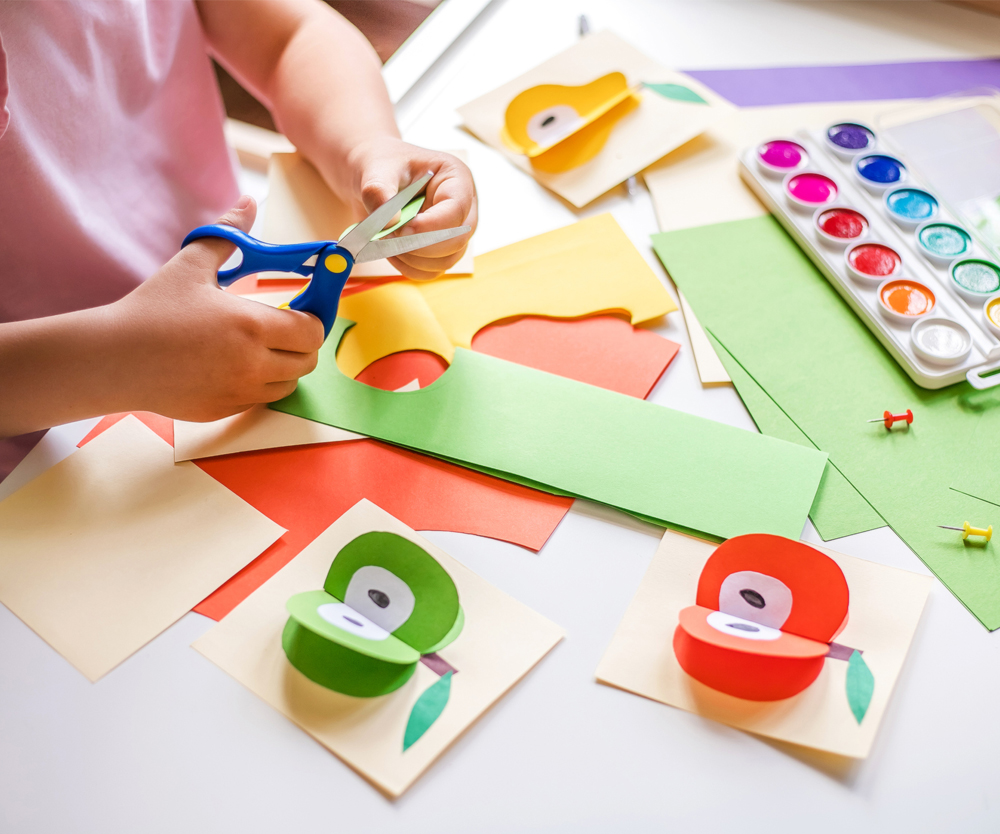 Image showing child's hands cutting craft paper
