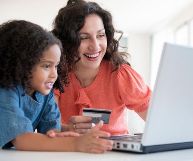 Woman and daughter shopping on laptop