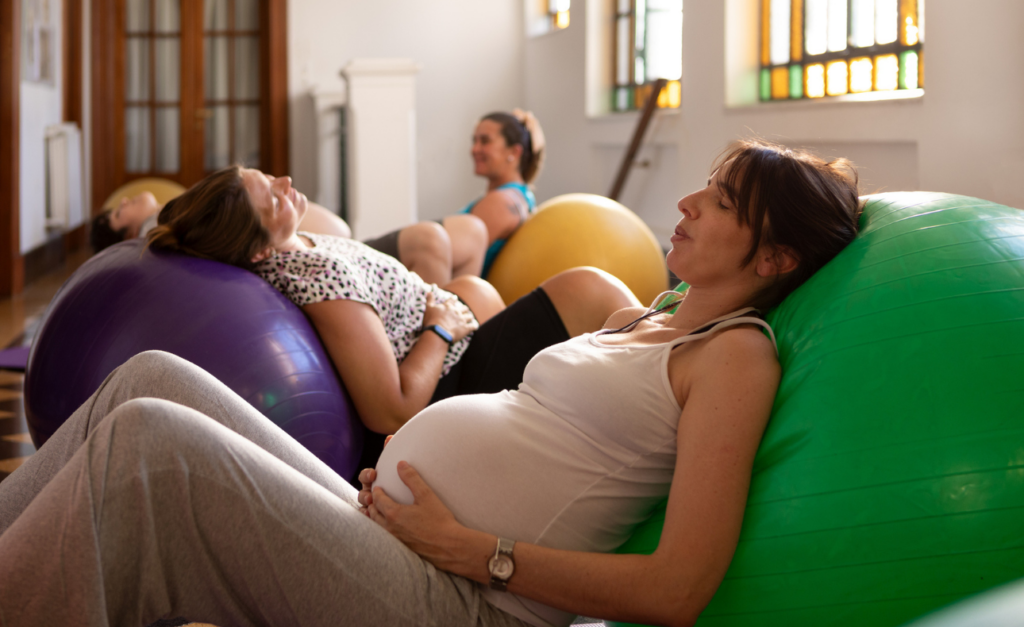 Pregnant women lying on their backs on different coloured cushions