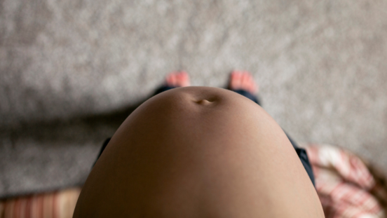 Top view of bare pregnant tummy