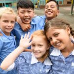 Five school friends posing for candid photo in playground