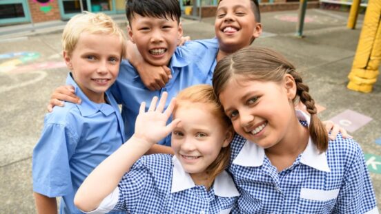 Five school friends posing for candid photo in playground