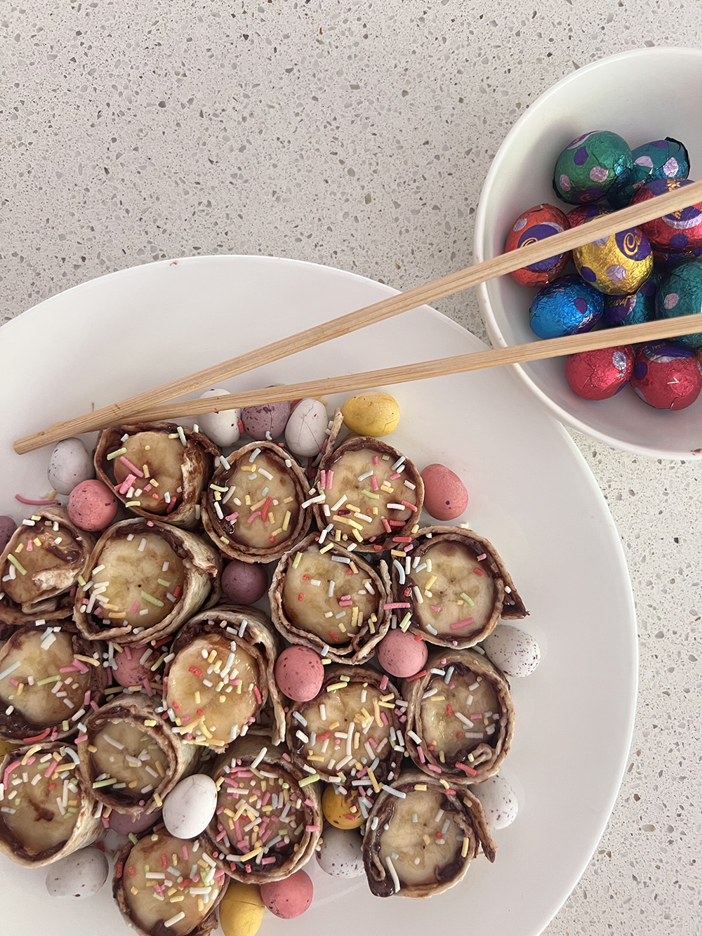 Nutella and Banana Sushi plated with Easter eggs and chopsticks