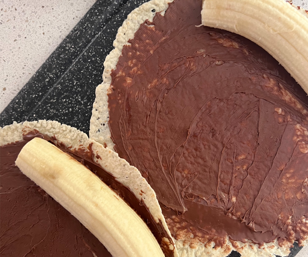 Banana sitting on Nutella spread low carb wrap