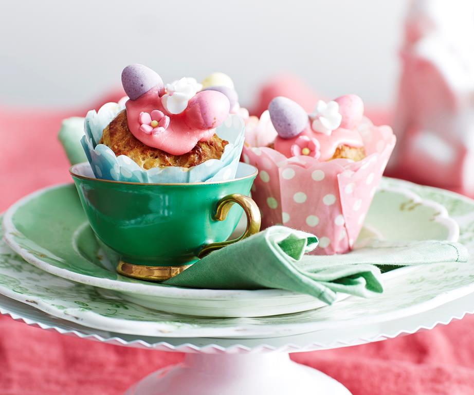 Two pretty Easter buns in cupcake papers on china plates