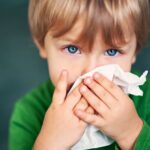 Portrait of a sick boy cleaning his nose