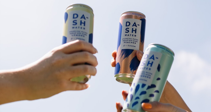 dash drinks held up in air with sky background.