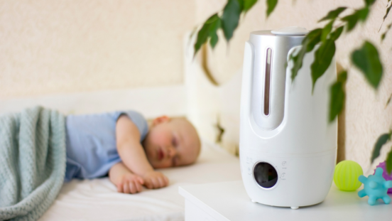 Baby sleeping on his side with a dehumidifier nearby