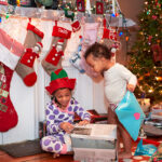 Mixed race children opening Christmas gifts