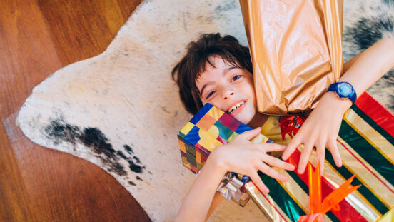 Young teenager boy holding Christmas presents.