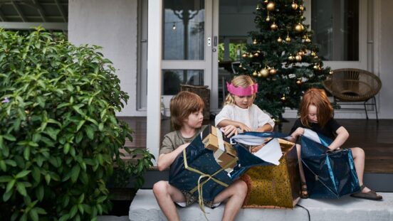 Three kids opening Christmas presents Australia