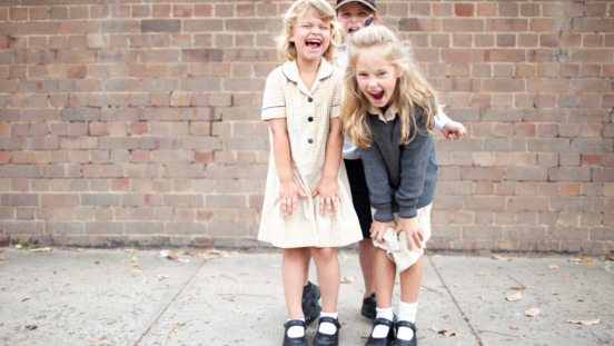 Three school kids wearing uniform and shoes