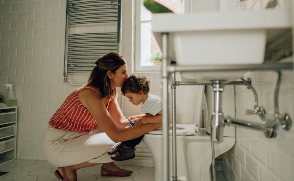 Scared of pooing: ttle boy learning to use toilet amenities with a little help from his mother
