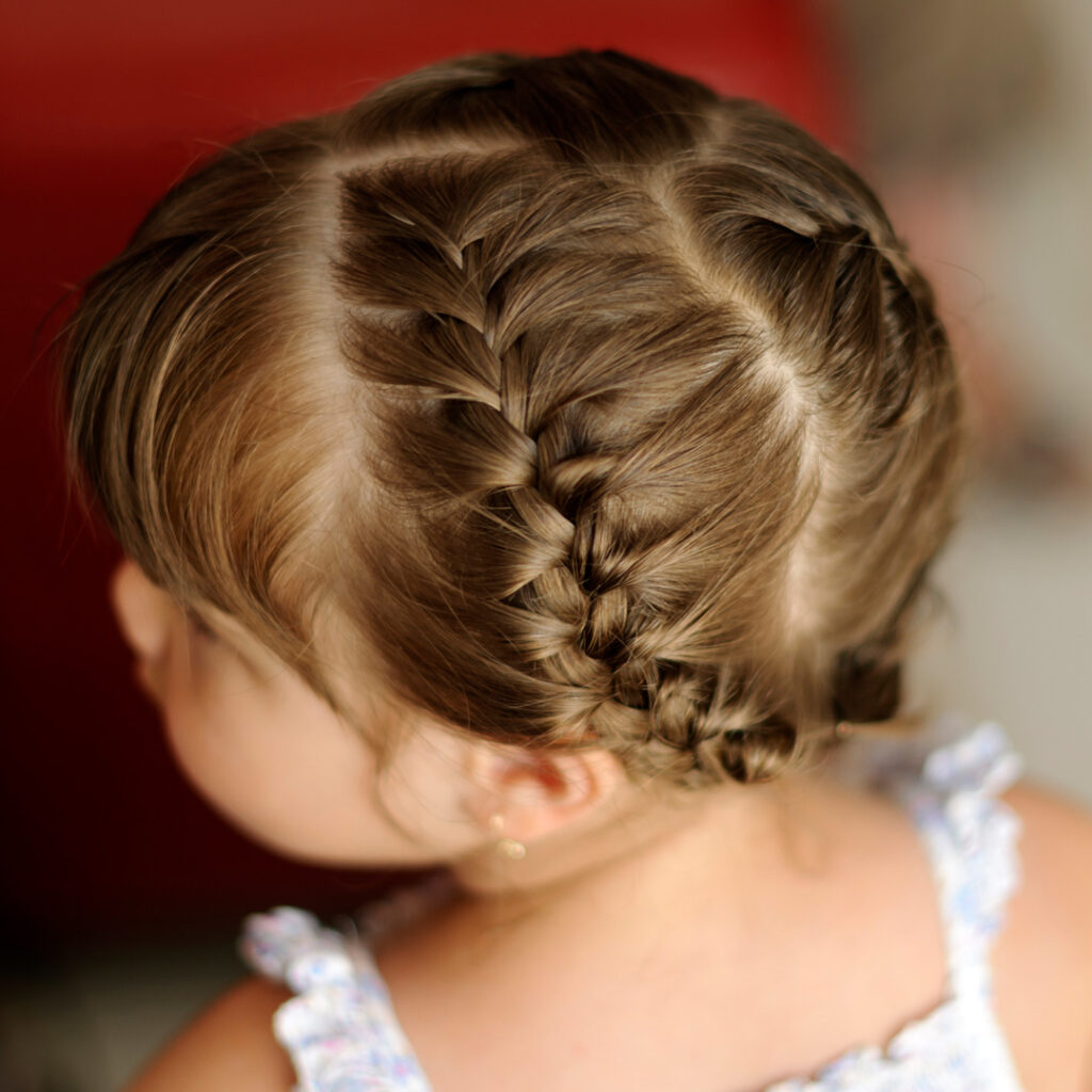 high angle view of little girl head with braided hairstyle.