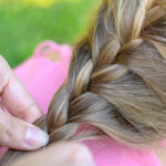 Close-up of hair on young girl being braided.