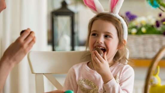 girl eating easter chocolate and wearing bunny ears