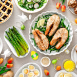 Easter festive table with salmon, asparagus, salad, potato, muffins and berry pie