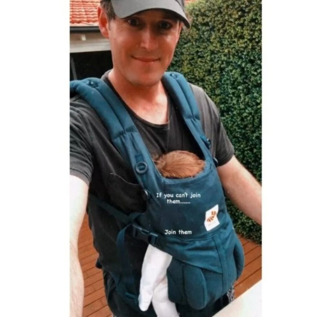 Lachy Wiggle Gillespie with one of his baby girls in a baby carrier