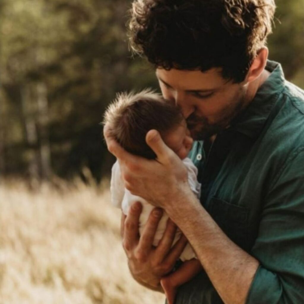 Lachy Wiggle Gillespie kisses the forehead of his daughter