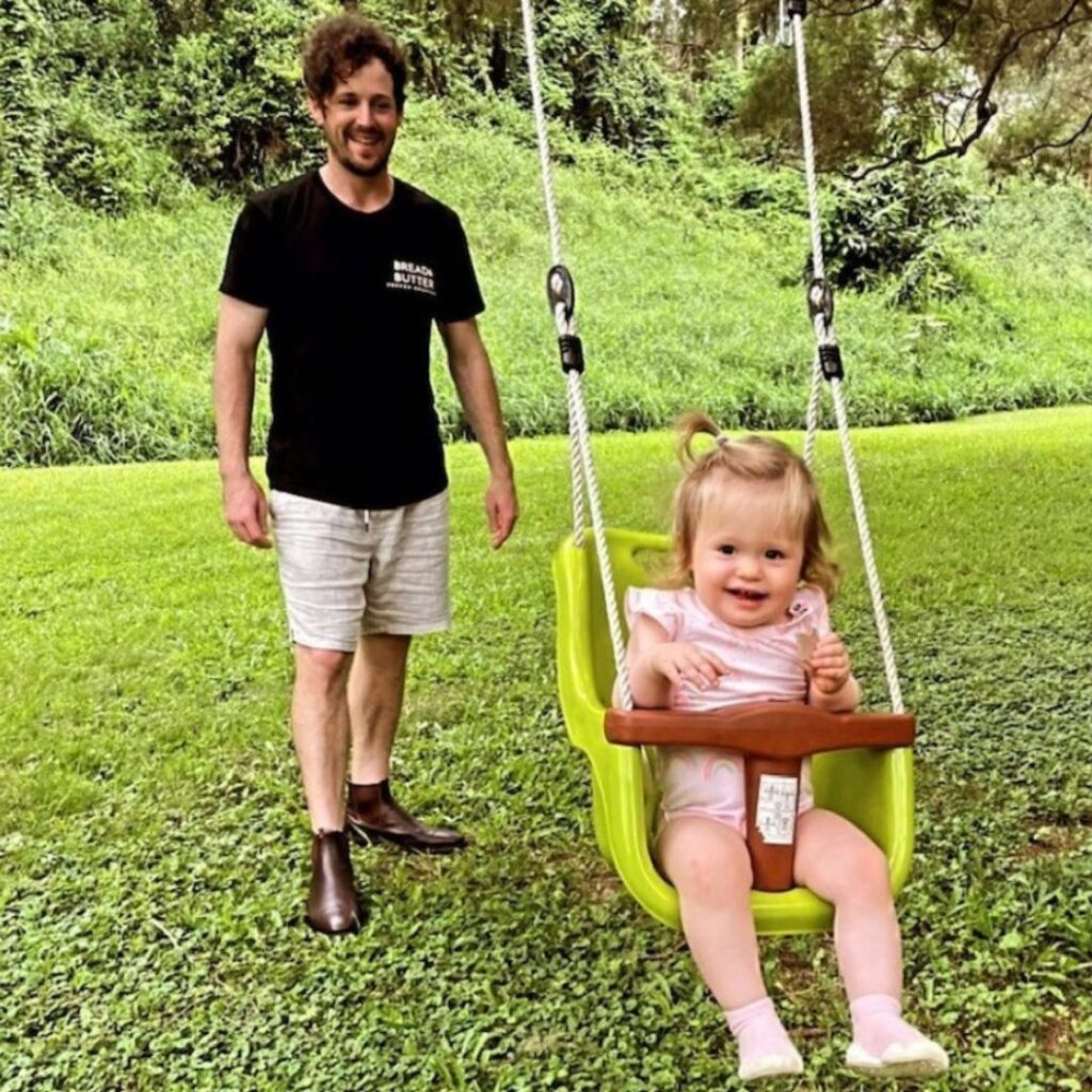 Lachy Wiggle Gillespie pushes one of his daughters on a swing