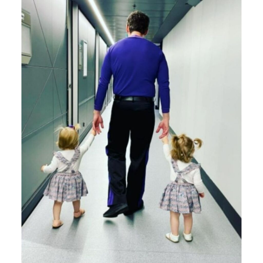 Lulu and Lottie walking with dad, Lachy Wiggle backstage at a Wiggles show