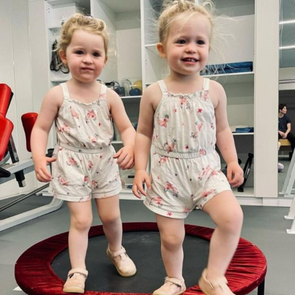 Lulu and Lottie, Lachy Wiggle's daughters, stand on a mini trampoline