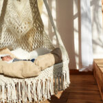 Baby sleeping in a circular hanging woven hammock bed