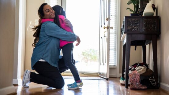 Mother hugging daughter