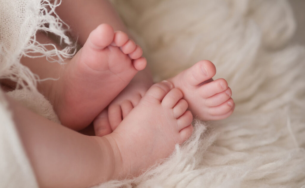 Intertwined twin baby feet.