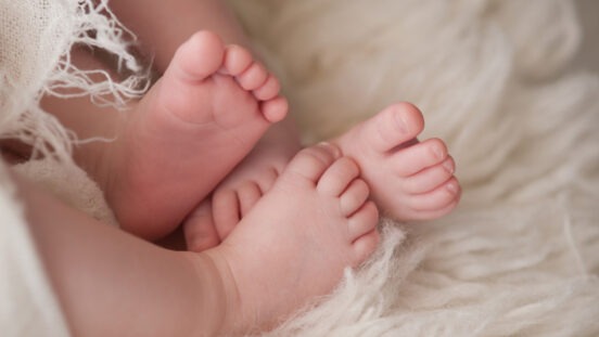 Intertwined twin baby feet.