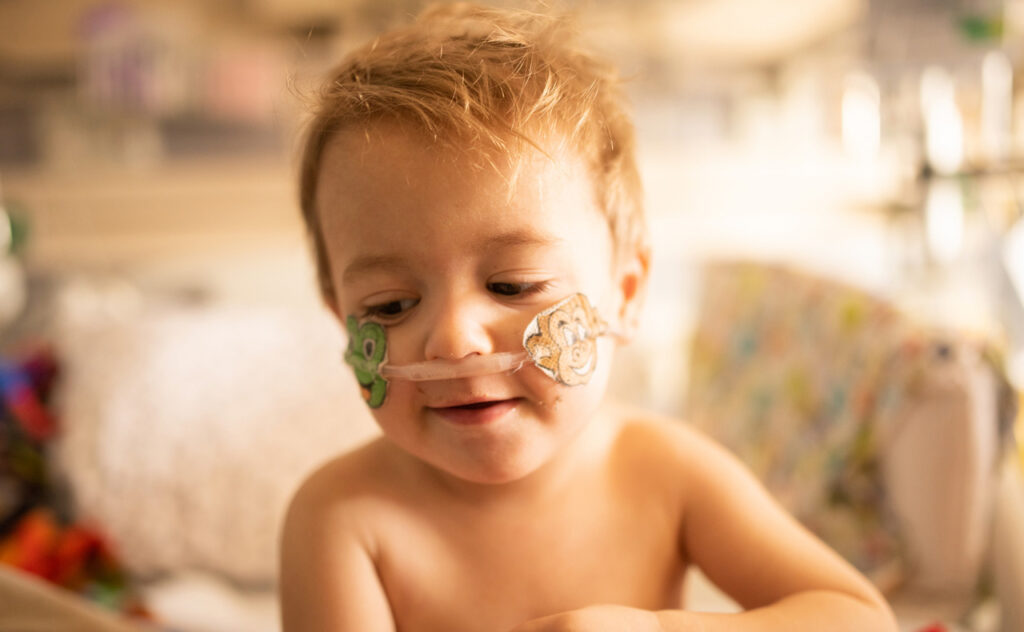 A child​ is in a hospital bed recovering from respiratory distress and viruses over winter.
