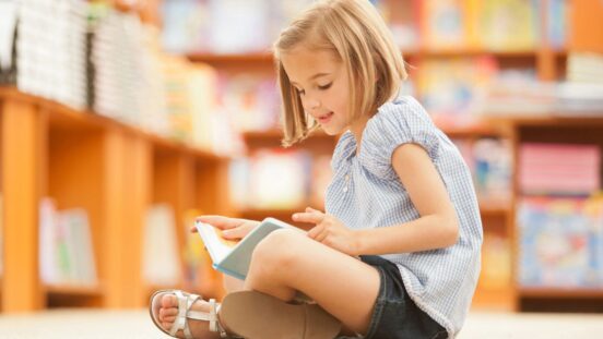 Young girl reading in library