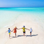 a family plays and has fun on a strip of sand during a splendid sunny day on The Great Barrier Reef